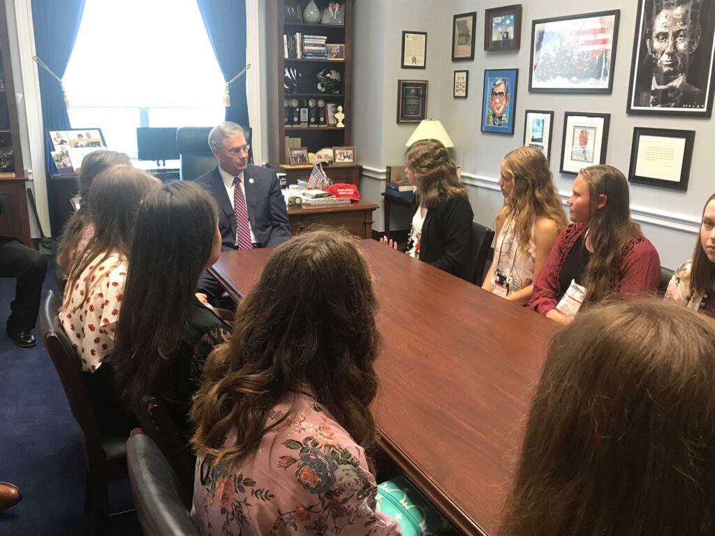 Sophomore's sitting at a table with a government official.